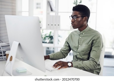 Shot of a young businessman working on a computer in an office - Shutterstock ID 2012470700