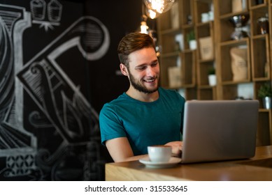 Shot of a young businessman working on his laptop in a cafe shop. Selective focus. - Powered by Shutterstock