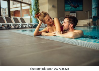 Shot of a young couple hugging in the swimming pool