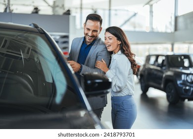 Shot of a young couple looking at cars at a car dealership. I think we can both agree that this is the car for us. Visit to the dealership.  - Powered by Shutterstock