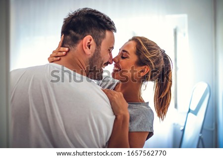 Shot of a young couple sharing an intimate moment in their bedroom. Couple on Valentine day enjoy in love. They are in bedroom and having romantic moment together