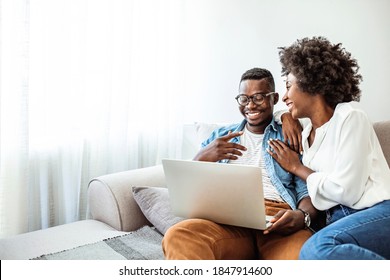 Shot of a young couple using a laptop on the sofa at home. Couch surfing has become their favourite hobby. Shot of a young couple using a laptop while relaxing at home - Powered by Shutterstock