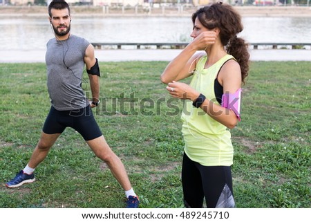 Shot of a young couple warming up for a daily run together outdoors