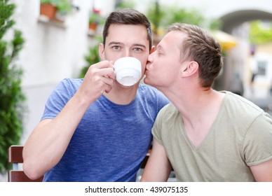 Shot Of A Young Gay  Couple  Kissing In A Cafe