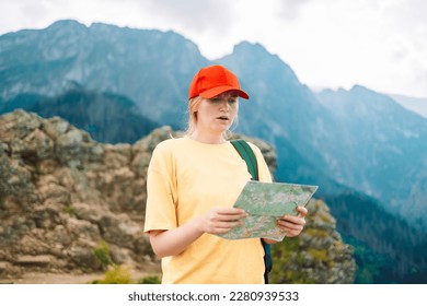 Shot of a young lost woman holding a map while taking in the view from the top of a mountain. Girl tourist in mountain read the map. Poland, Tatry  - Shutterstock ID 2280939533
