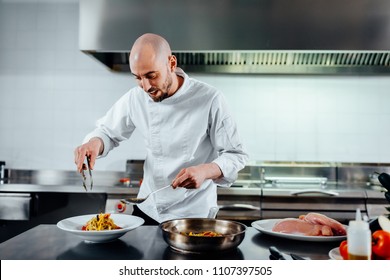 Shot of a young male chef serving the food in a professional kitchen