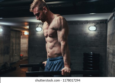 Shot Of A Young Man Doing Dips At The Gym