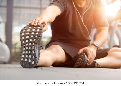 Shot of a young man stretching his legs before a gym workout - Shutterstock ID 1008221251