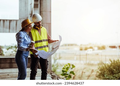 Shot of a young man and woman going over building plans at a construction site. Civil Engineers Checking Works According To Project Using blue prints At Construction Site - Powered by Shutterstock