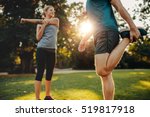 Shot of young man and woman stretching in the park. Young couple warming up in morning.