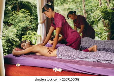 Shot Of Young People At Outdoor Spa And Getting Body Massage At Resort. Couple Having Back Massage At Luxury Resort Spa Center.