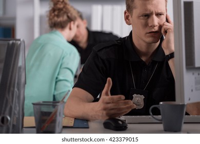 Shot Of A Young Police Officer Talking On The Phone At A Police Station