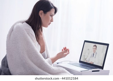 Shot Of A Young Woman Talking With Her Doctor Via Video Chat In A Very Bright Interior