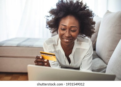 Shot Of A Young Woman Using A Laptop And Credit Card While Relaxing At Home. Keeping The Shopping Mall Close To Home. Shopping Spree Directly From The Sofa 