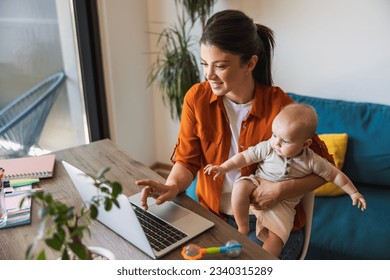 Shot of a young woman working on laptop while caring for her adorable baby girl at home. - Powered by Shutterstock