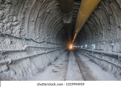 Shotcrete Work. Tunnel Construction Site. Air Ventilation Pipe. Railway For Mucking Loader Train.