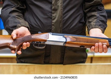 Shotgun In The Hands Of A Man. Demonstration Of Modern Firearms In A Specialized Store. Unrecognizable Person. Close-up