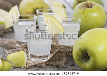 Shots of Apple Liqueur on vintage background