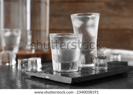 Shots and bottles of vodka on dark table