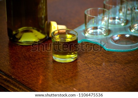 Shots of hard liquor (rakija) with bottle in the  background