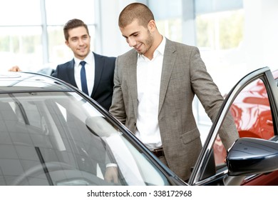 Should Try It By Himself. Young Businessman Getting Into The New Car At The Car Salon