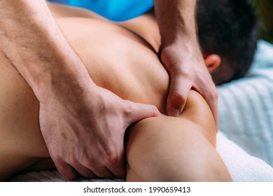 Shoulder blade or scapula pone physical therapy. Physiotherapist massaging patient’s shoulder. Sports injury treatment.
