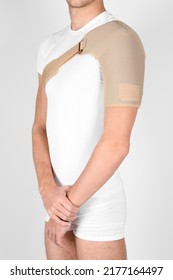 Shoulder Joint Orthosis Or Brace Isolated On White Background. A Man In A Support Orthopedic Bandage On His Arms After Surgery, Suffering From Shoulder Pain, The Result Of A Work Injury.