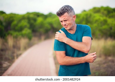 Shoulder pain. Man with arm injury outdoor. Healthcare and medicine concept