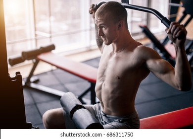 Shoulder Pull Down Machine. Fitness Man Working Out Lat Pulldown Training At Gym. Upper Body Strength Exercise For The Upper Back.