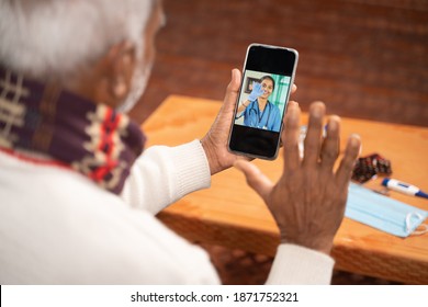 Shoulder Shot Of Old Man On Video With To Doctor On Mobile Phone - Concept Of Nurse Online Chat, Telehealth, Or Tele Counseling During Coronavirus Or Covid-19 Pandemic.