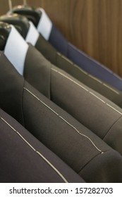 shoulder of suits hanging with thread sewed on them