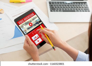 Shoulder View Of Woman Watching Video Online With Advertising On Digital Tablet Computer At Home.viral Influencer Media Concept