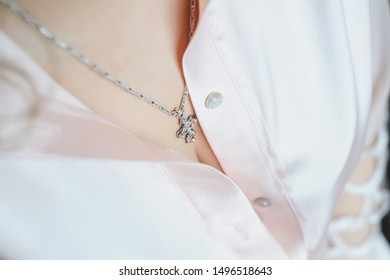 Shoulders and neck of a girl. Morning preparation of the bride. Necklace on the neck. Woman's breast. Beautiful decollete. Closeup.