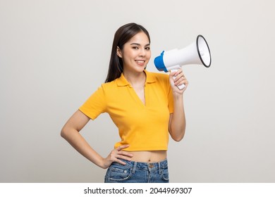 Shout out loud with megaphone. Young beautiful asian woman woman announces with a voice about promotions and advertisements for products at a discounted price. Shopping and fashion concept. - Shutterstock ID 2044969307