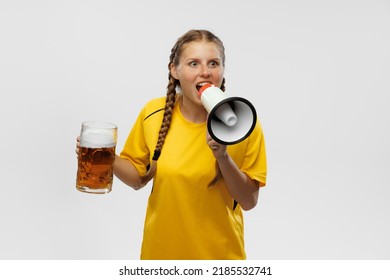 Shouting At Megaphone. Young Excited Girl In Yellow Football Kit Holding Beer Mug And Supports Favorite Team Isoltaed Over White Background. Soccer Fans, Competition, Sport, Oktoberfest Concept.