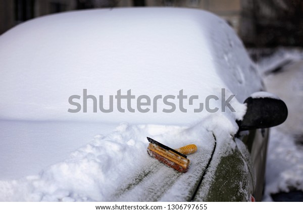 A shovel for cleaning is on\
the car covered with snow, transport and transportation, winter\
travel
