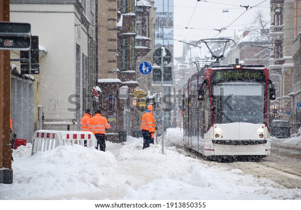 Shoveled snow from the street for the tram and the\
bus to cross