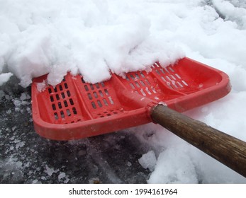 Shoveling Snow With A Red Snow Shovel