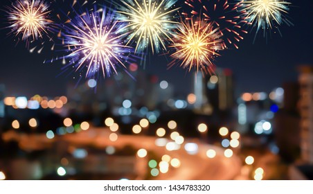 show group of exploding fireworks bright light colorful and falling fire glitter on blur city buildings background for happy new year,diwali,labor's day ,independence's day and malaysia's day concept