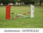 Show jumping poles obstacles, barriers, waiting for riders on show jumping training. Horse obstacle course outdoors summertime. Poles in the sand for equestrian event