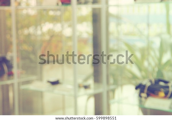 Show\
room customer service of car part, blur background decor garden\
concept, Photo in office looking out of shelf and glass wall to\
relax, has green garden and tree, color retro\
tone.