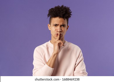 Show Some Respect. Portrait Of Angry And Annoyed, Displeased Young Hispanic Man Telling To Keep Quiet, Shushing At Someone Being Too Loud, Hold Index Finger Over Mouth Frowning, Scolding Person