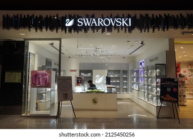 Showcase of a boutique of Swarovski jewelry. Swarovski - Austrian lead glass manufacturer. Swarovski swan symbol and logo on a store front. : Dubai UAE - February 2022