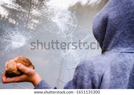 Showcase with broken glass during a protest in a city with protesters.