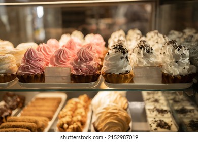 Showcase with cakes and pastries in the store. Cakes and pastries for every taste in the showcase. cake creame basket in display window of pastry shop. Variety of cakes and desserts on cafe in store.