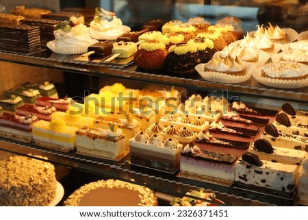 Showcase with different tasty desserts in bakery shop, closeup