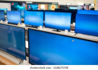 Showcase With Plasma TVs With Blue Screen In Store Of Household Appliances, Electronics And Gadgets. Buying New TV, Sale Day.