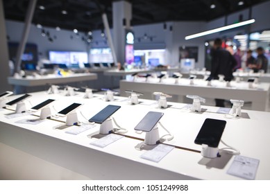 Showcase with smartphones in the modern electronics store. Buy a mobile phone. Many smartphones on the shelf of the technology store