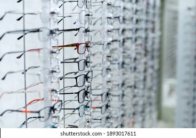 Showcase with spectacles in modern ophthalmic store. Stand with glasses in the store of optics. Closeup.