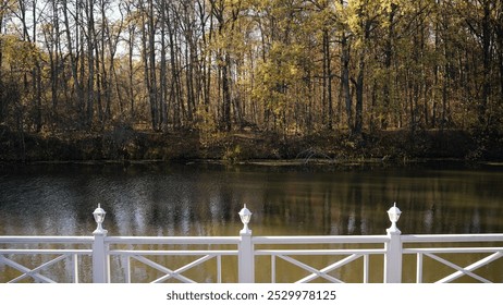 showcasing a serene lake and vibrant forest in autumn from a white wooden bridge. - Powered by Shutterstock